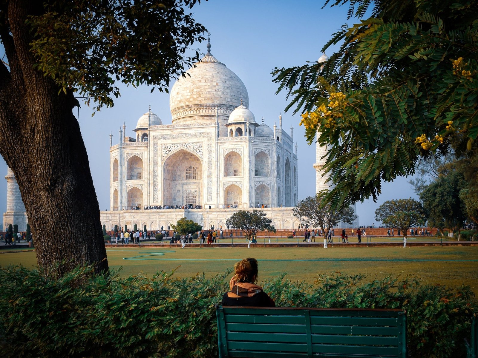 Female Tourist sitting Taj Mahal Garden and watching Taj Mahal